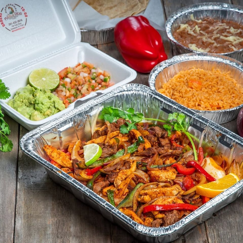 Pueblo Viejo fajita family pack with steak, chicken, rice, beans, guacamole, and pico de gallo.